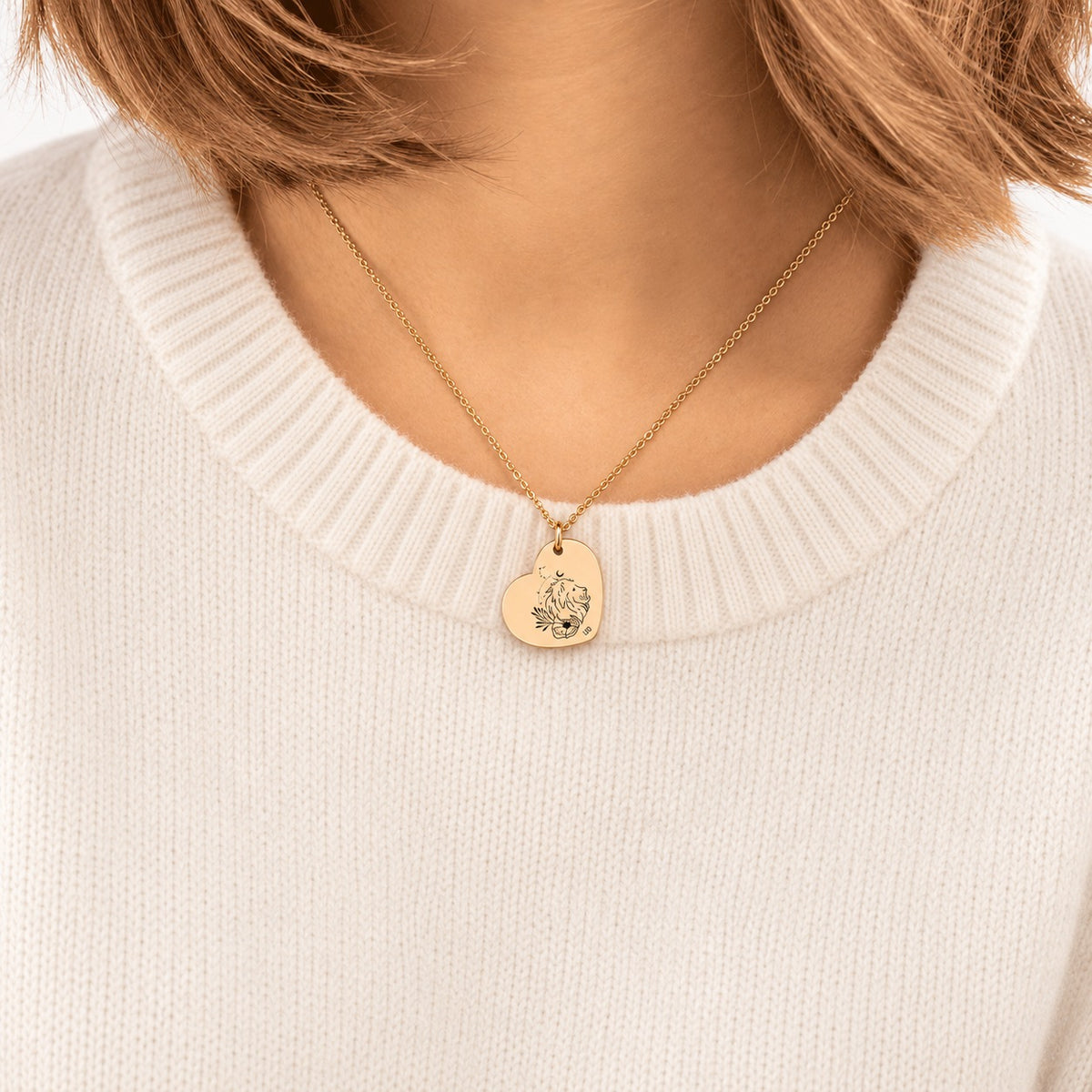 Collier cœur signe astrologique Lion doré porté au cou, médaille en cœur gravée.