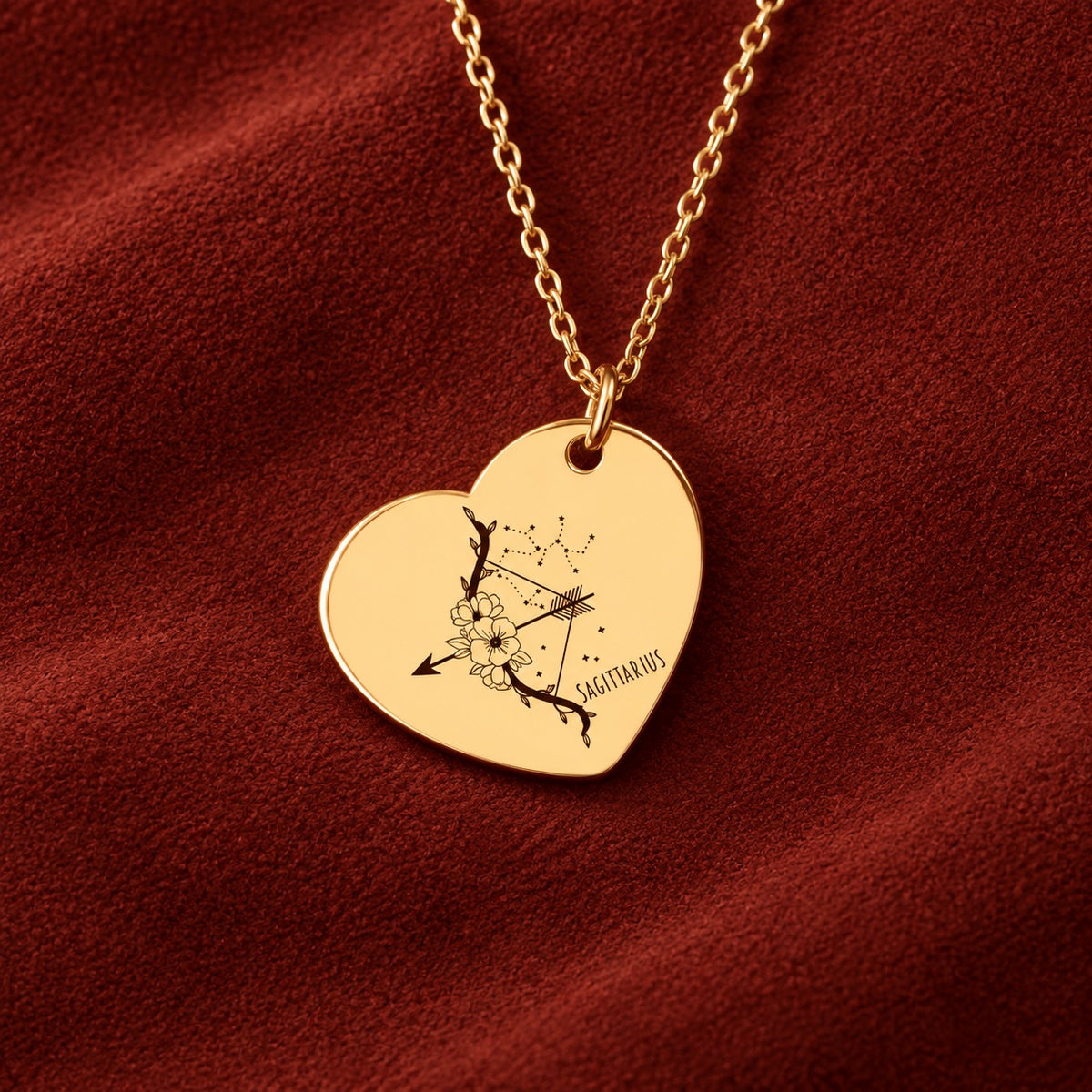 Médaille en cœur dorée avec motif du signe Sagittaire et ornements, sur suédine rouge sanguine.