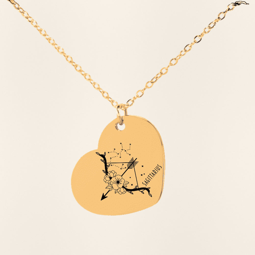Collier Coeur Signe Astrologique Sagittaire en finition dorée, exemple de gravure sur fond ivoire texturé.