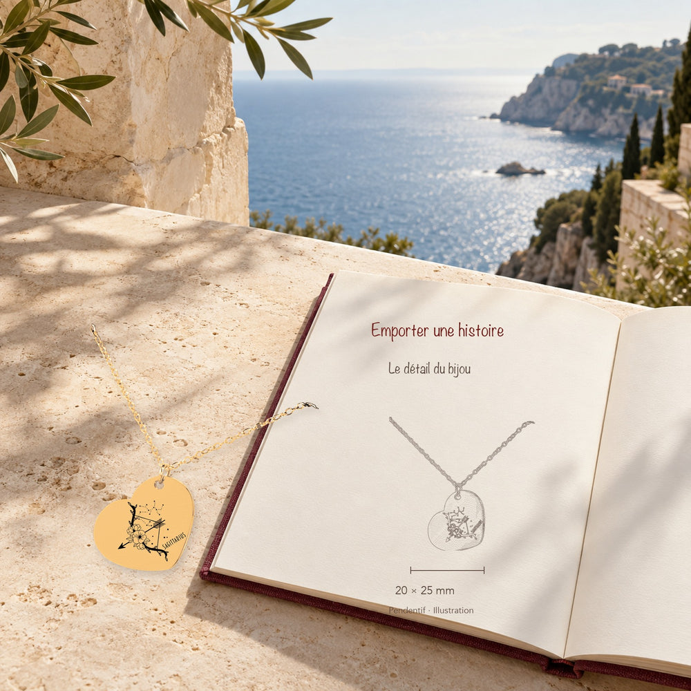 Collier Coeur Signe Astrologique Sagittaire en finition dorée dans un décor méditerranéen, avec dessin du produit sur un carnet.