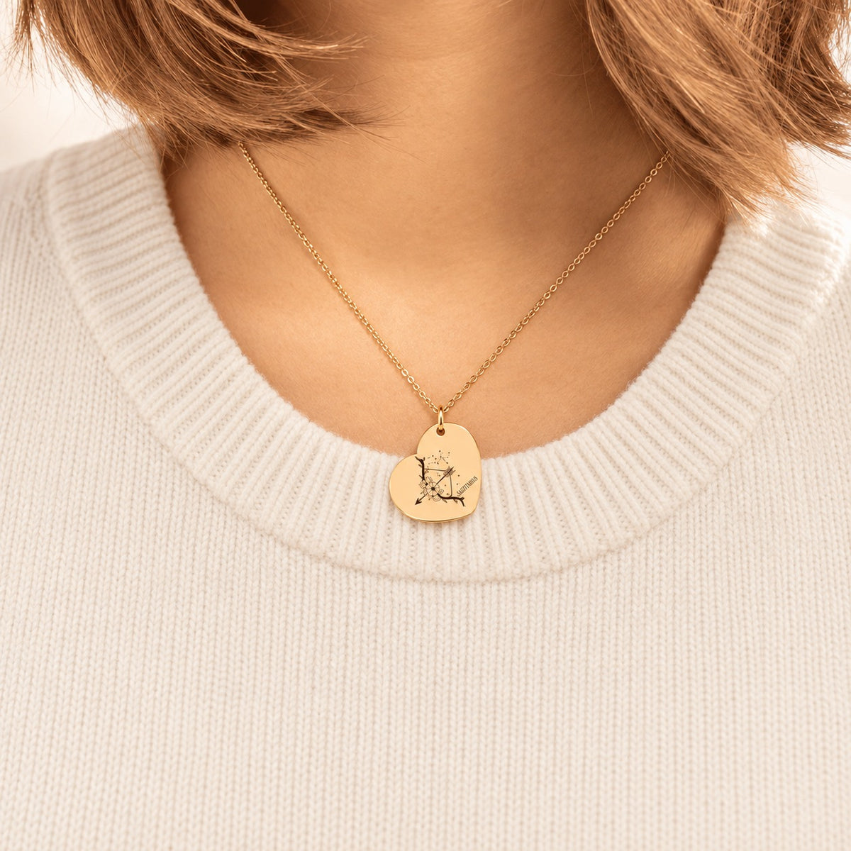 Collier cœur signe astrologique Sagittaire doré porté au cou, médaille en cœur gravée.