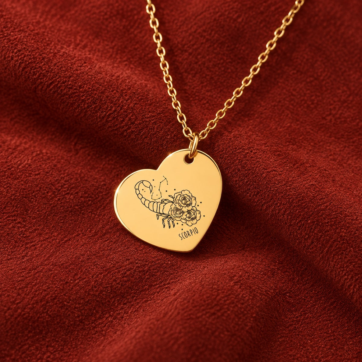 Médaille en cœur dorée avec motif du signe Scorpion et ornements, sur suédine rouge sanguine.