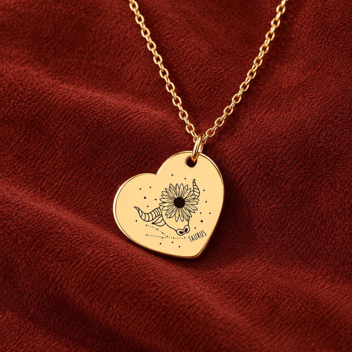 Médaille en cœur dorée avec motif du signe Taureau et ornements, sur suédine rouge sanguine.