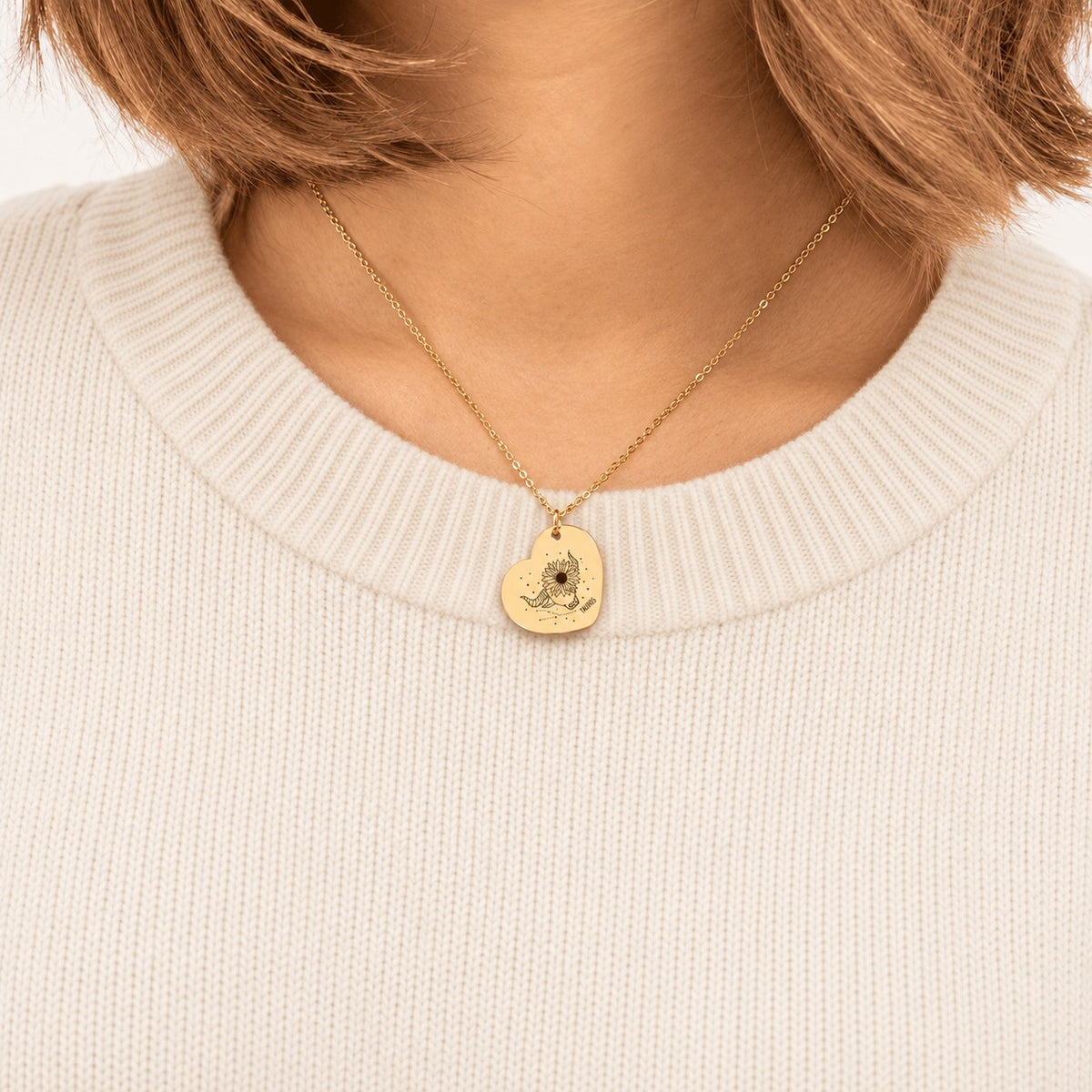 Collier cœur signe astrologique Taureau doré porté au cou, médaille en cœur gravée.