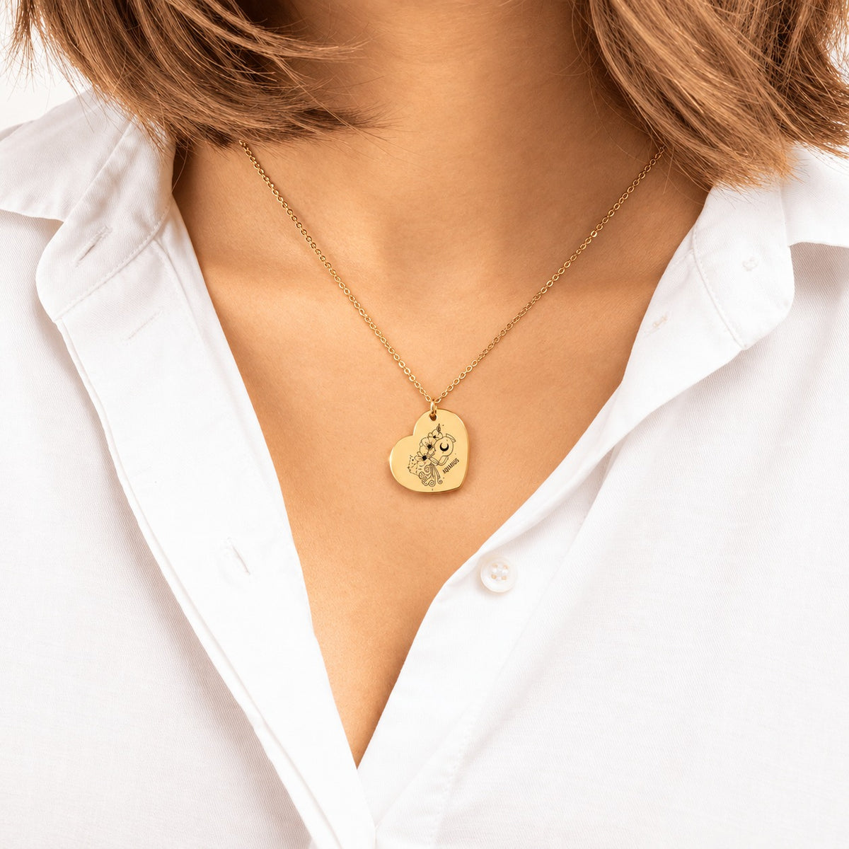Collier Coeur Signe Astrologique Verseau doré porté au cou, médaille en cœur gravée.