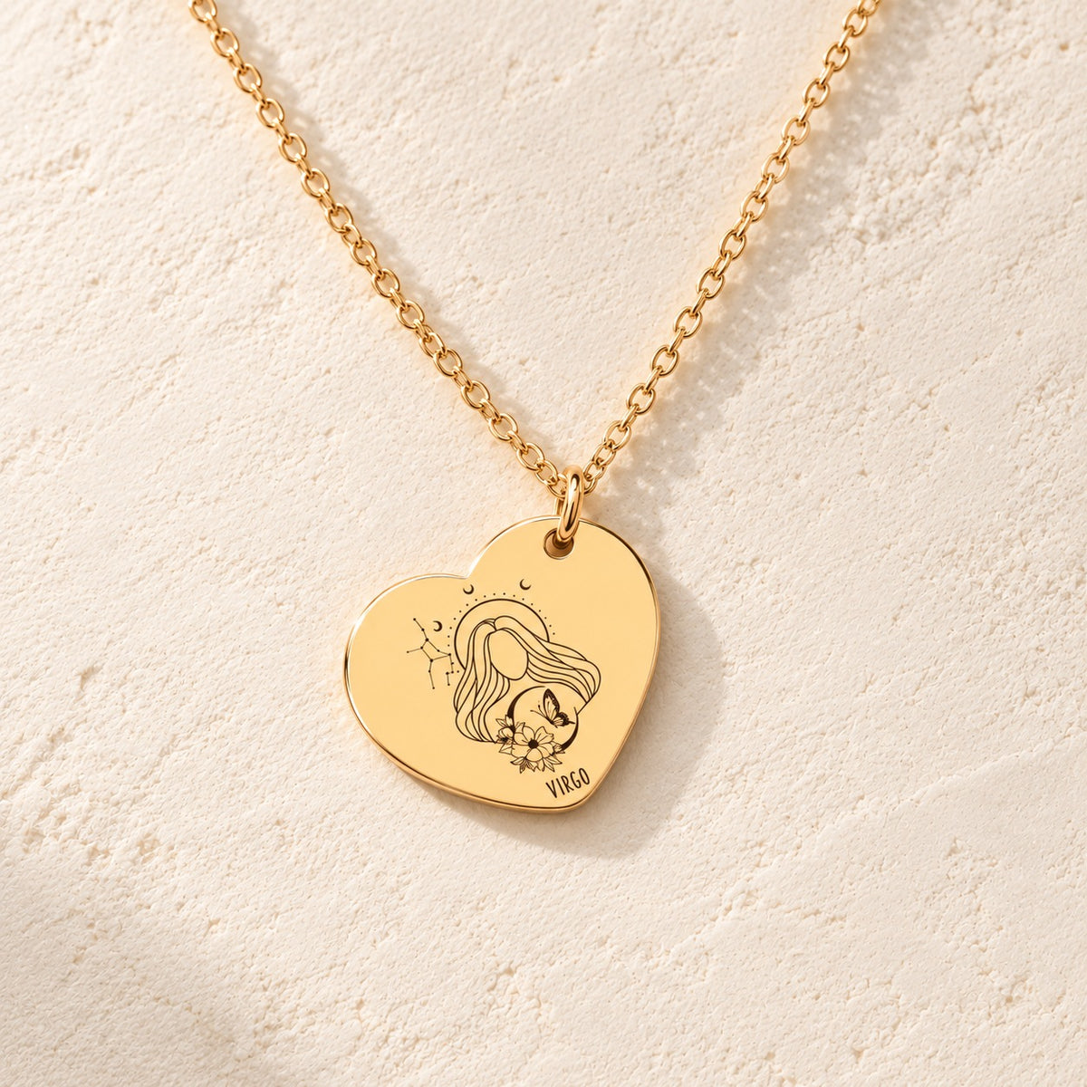 Détail de la médaille en cœur dorée avec motif du signe Vierge et ornements.