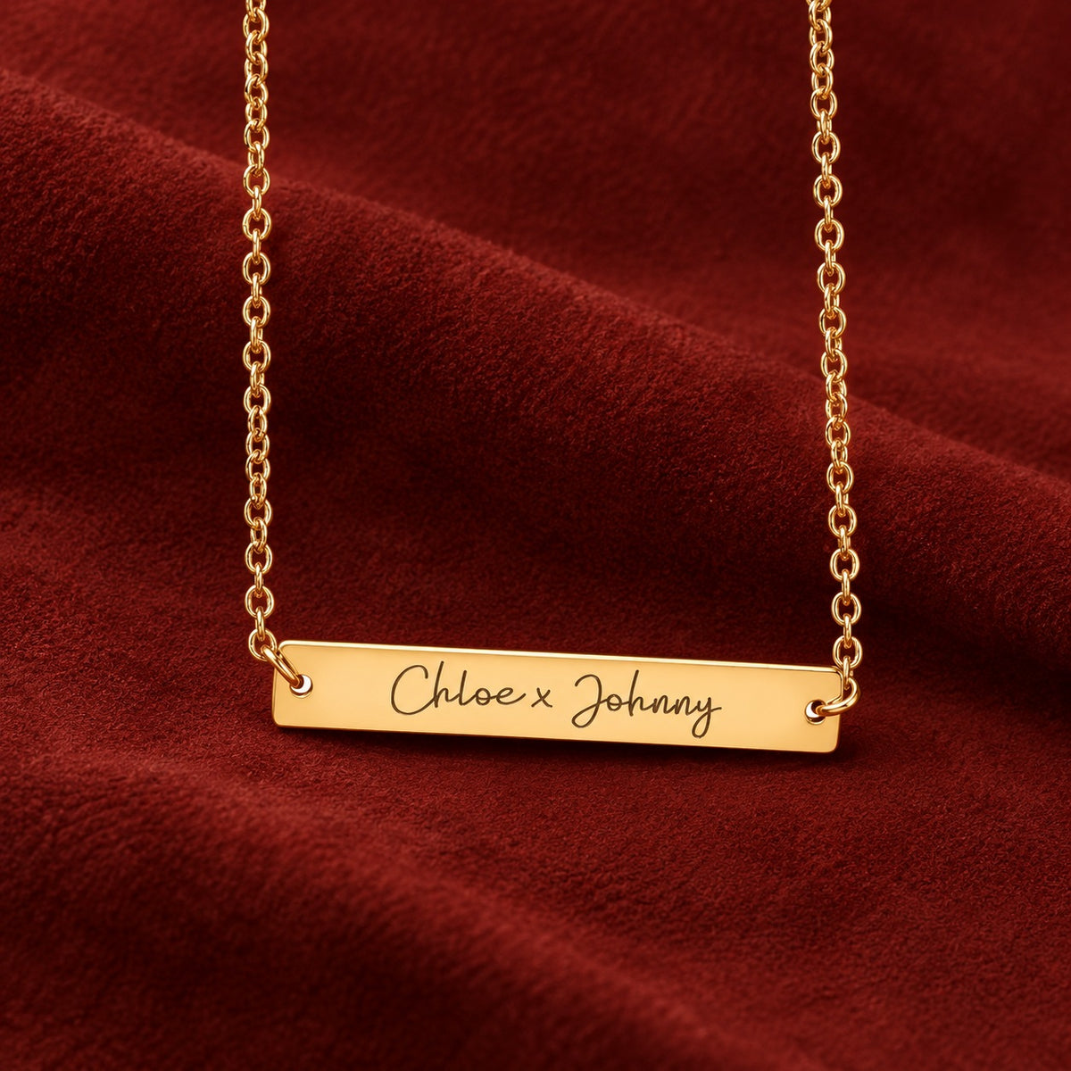 Barrette dorée gravée Chloe x Johnny sur suédine rouge sanguine.