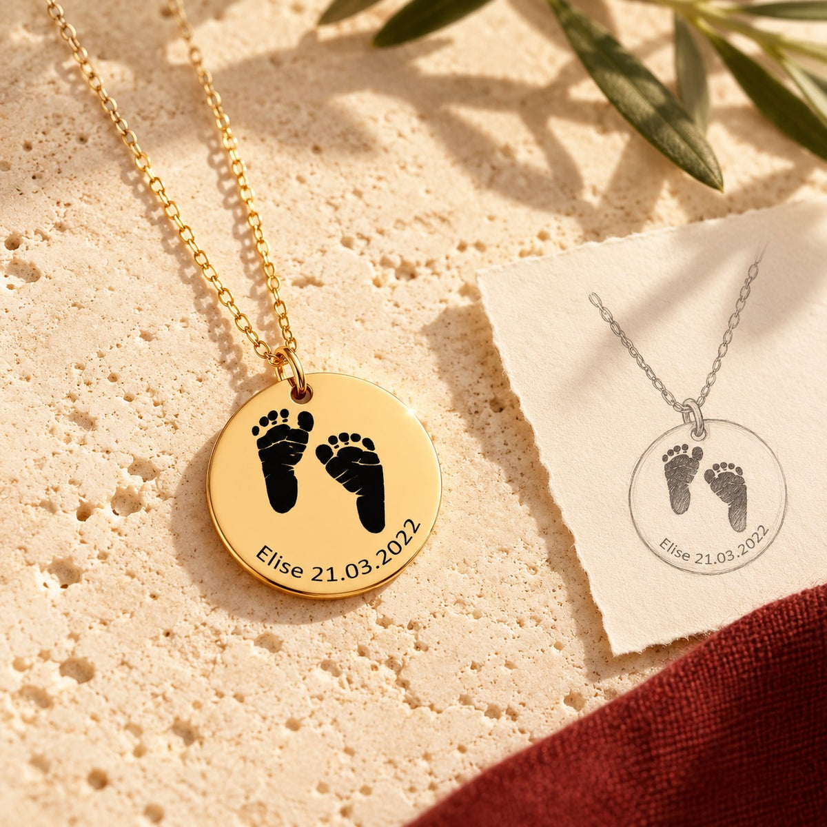 Collier Empreinte de Pied doré sur pierre claire, accompagné du dessin du bijou sur papier ivoire.