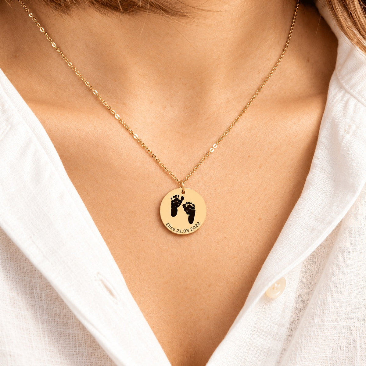 Collier Empreinte de Pied doré porté au cou, avec médaille ronde gravée.
