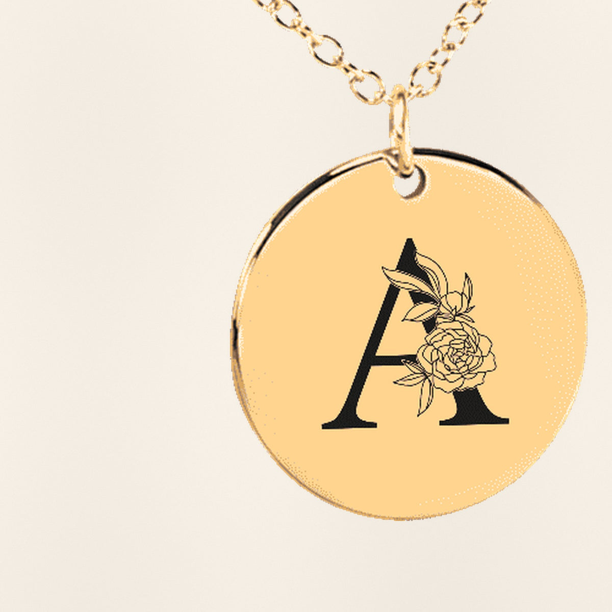 Collier Initiale Florale A Personnalisé : gros plan du motif gravé, exemple de personnalisation en finition dorée.