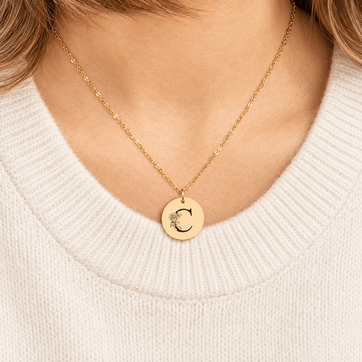 Collier initiale florale C personnalisé doré porté au cou, médaille ronde gravée.