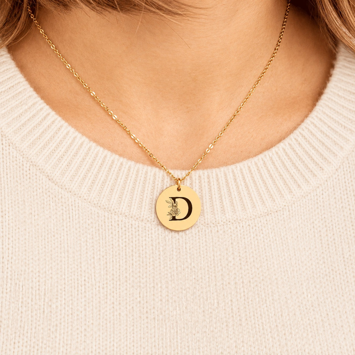 Collier initiale florale D personnalisé doré porté au cou, médaille ronde gravée.