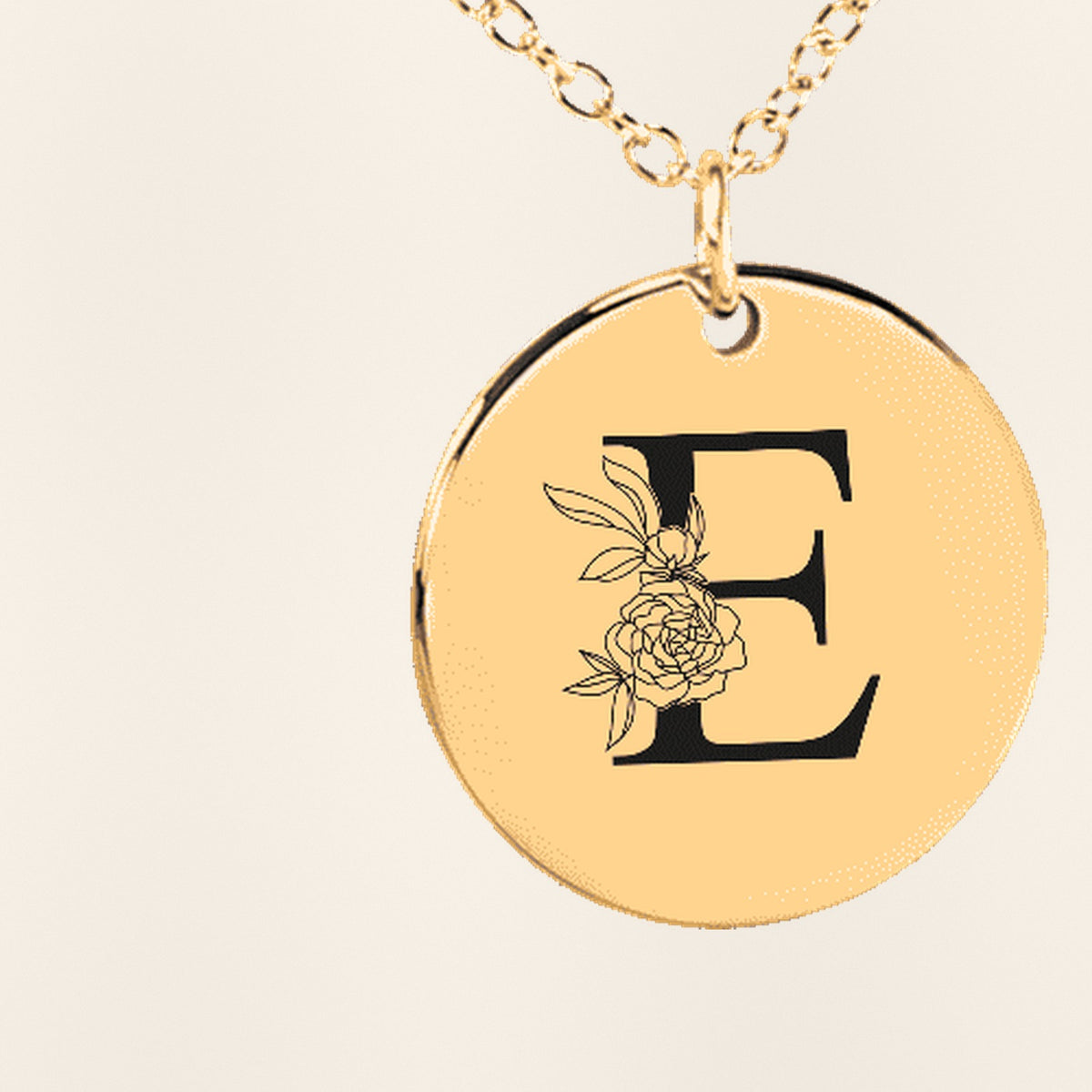 Collier Initiale Florale E Personnalisé : gros plan du motif gravé, exemple de personnalisation en finition dorée.