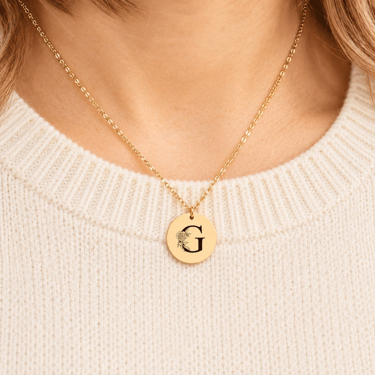 Collier initiale florale G personnalisé doré porté au cou, médaille ronde gravée.