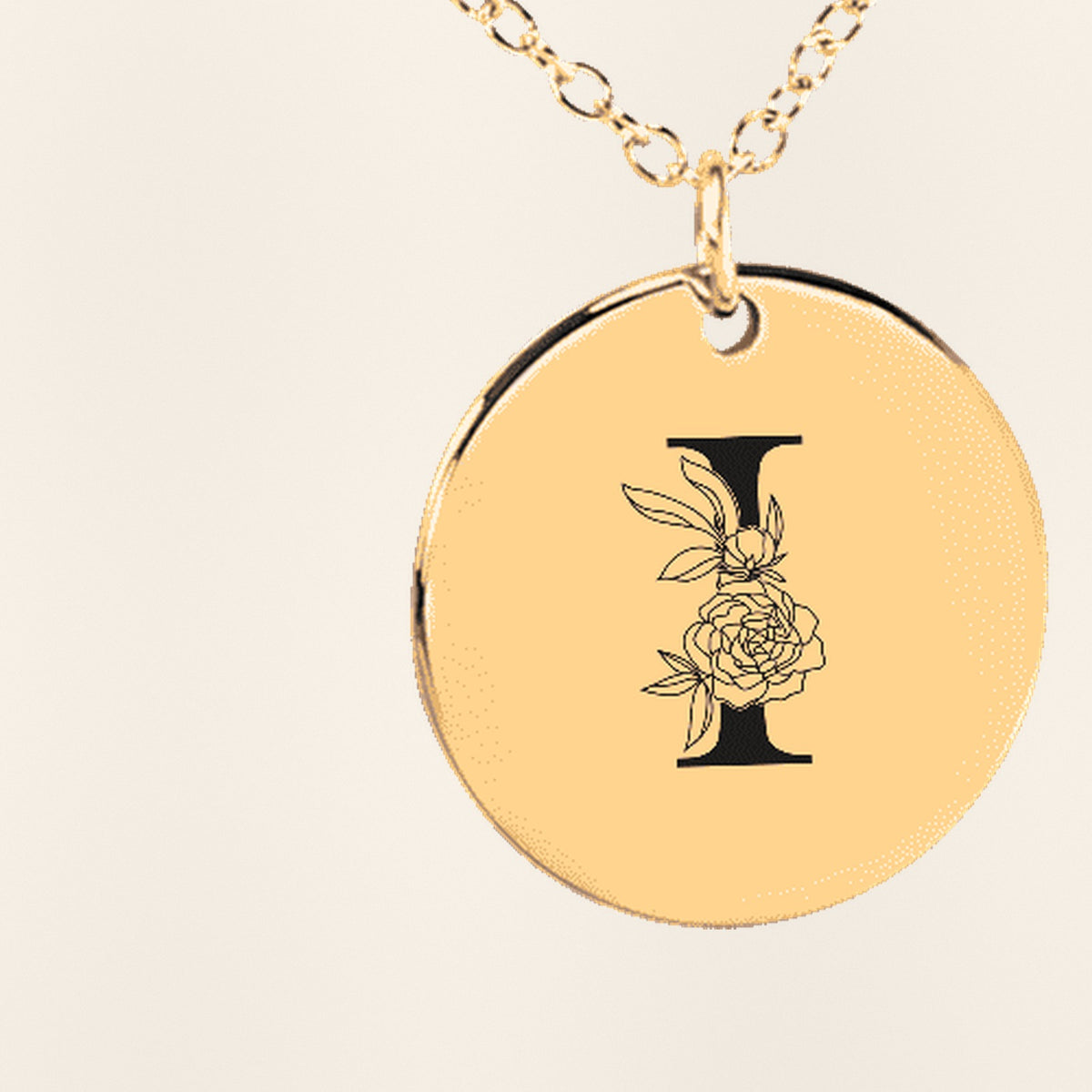 Collier Initiale Florale I Personnalisé : gros plan du motif gravé, exemple de personnalisation en finition dorée.