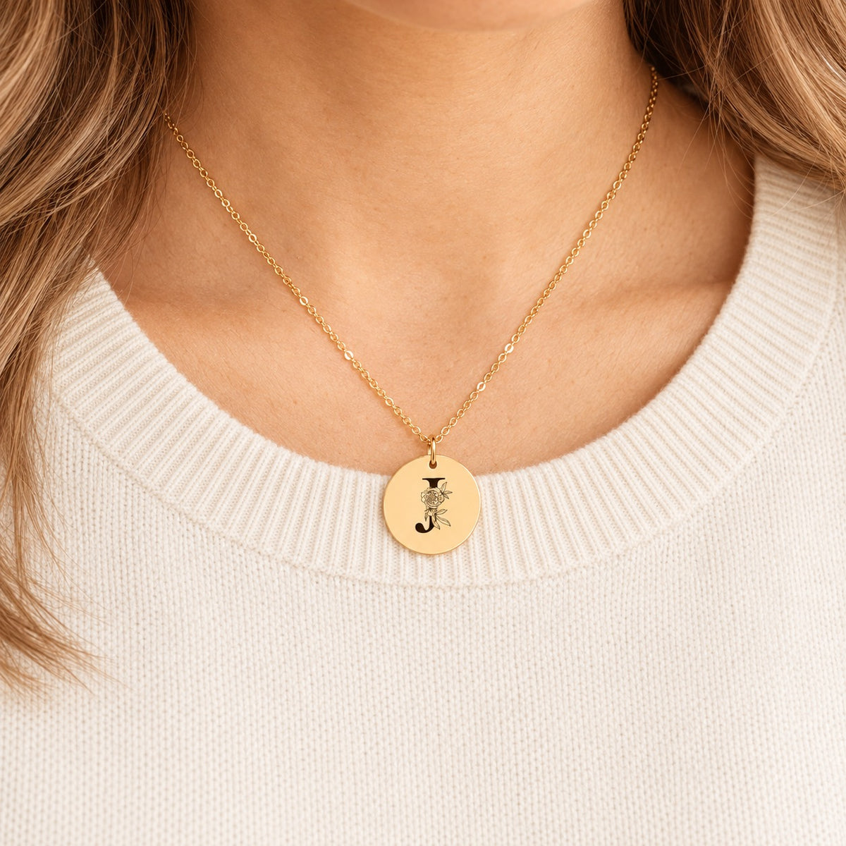 Collier initiale florale J personnalisé doré porté au cou, médaille ronde gravée.