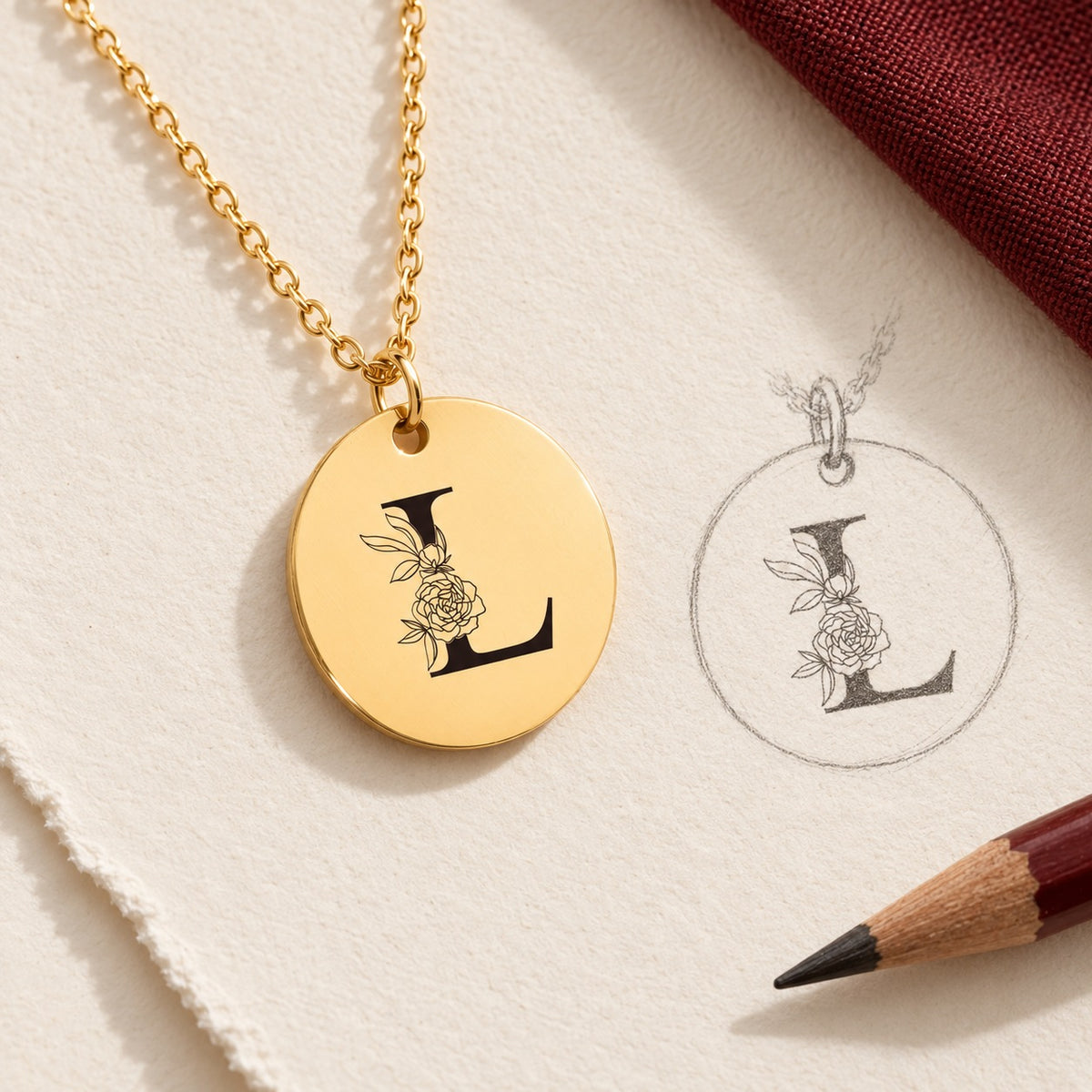 Collier initiale florale L personnalisé doré et étude au graphite du bijou sur papier ivoire.