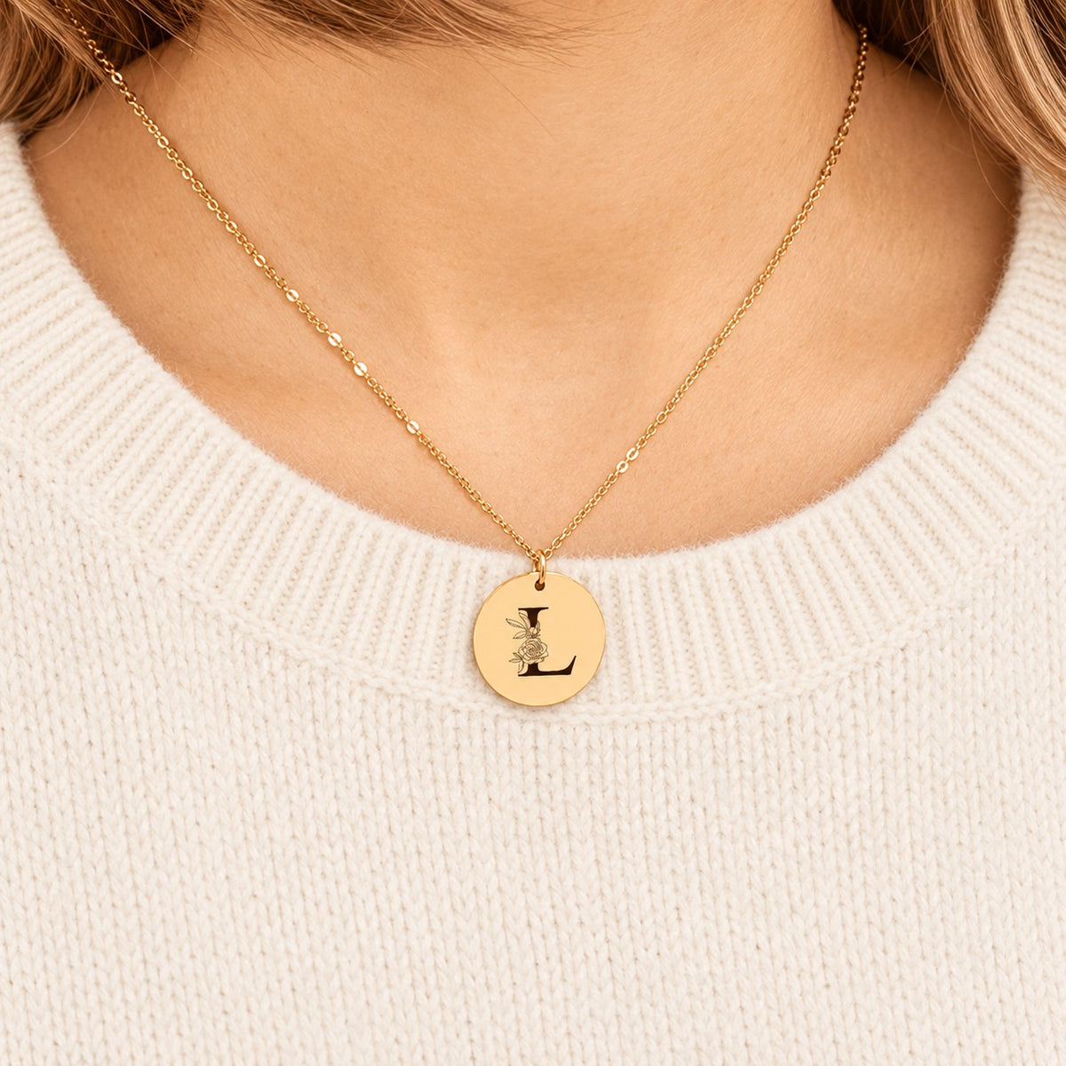Collier initiale florale L personnalisé doré porté au cou, médaille ronde gravée.