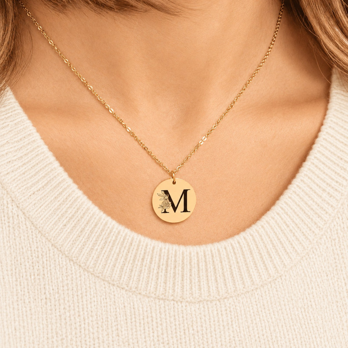 Collier initiale florale M personnalisé doré porté au cou, médaille ronde gravée.