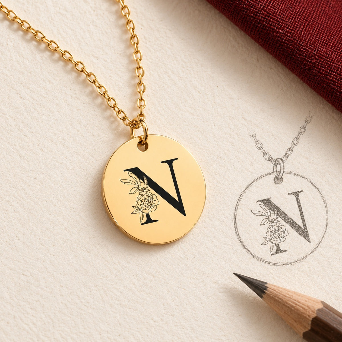 Collier initiale florale N personnalisé doré et étude au graphite du bijou sur papier ivoire.
