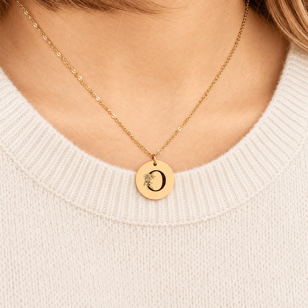 Collier initiale florale O personnalisé doré porté au cou, médaille ronde gravée.