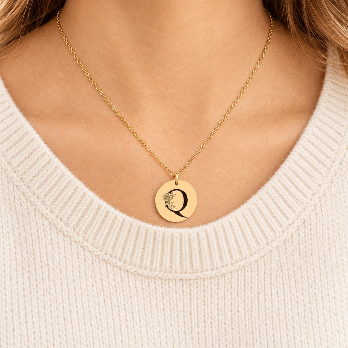 Collier initiale florale Q personnalisé doré porté au cou, médaille ronde gravée.