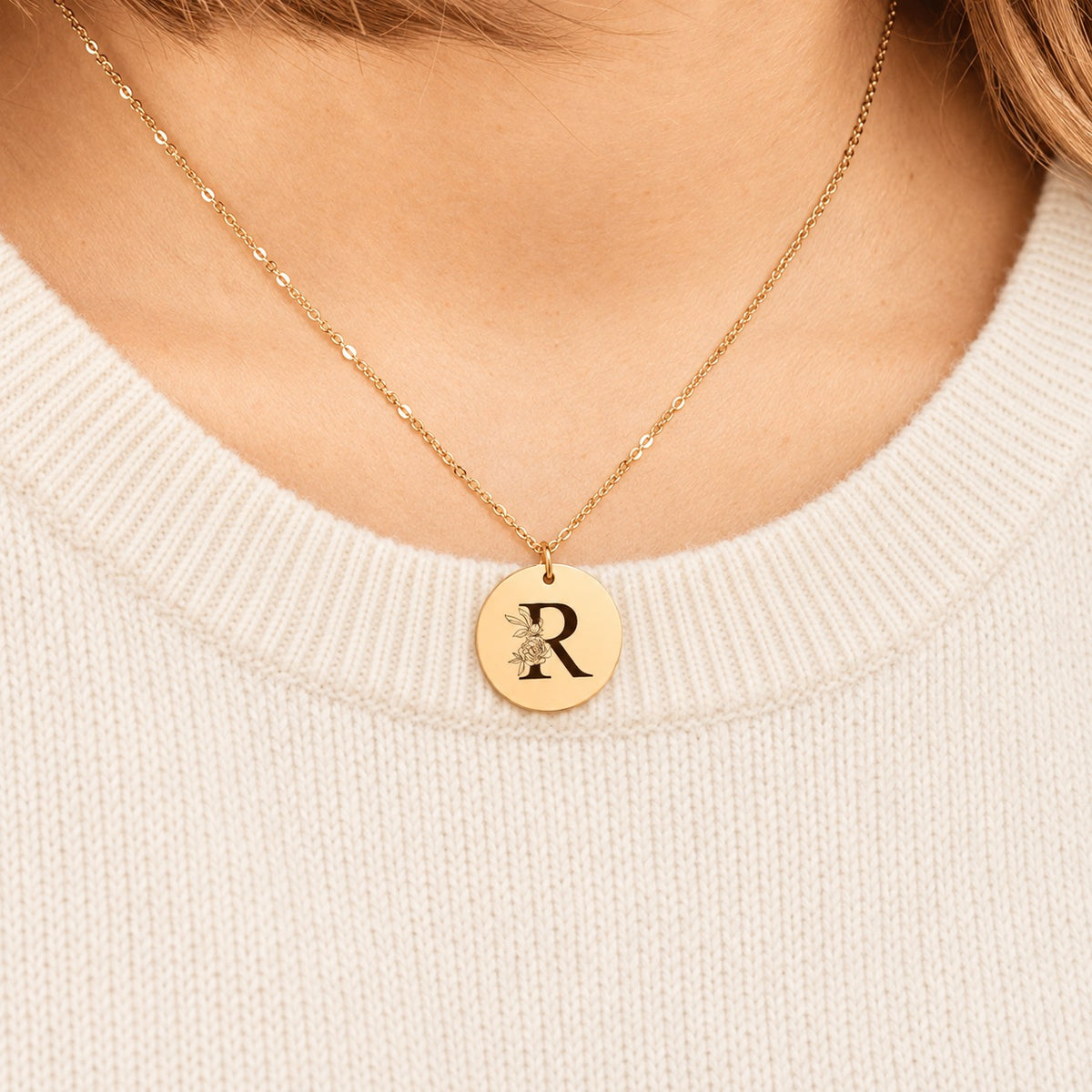 Collier initiale florale R personnalisé doré porté au cou, médaille ronde gravée.