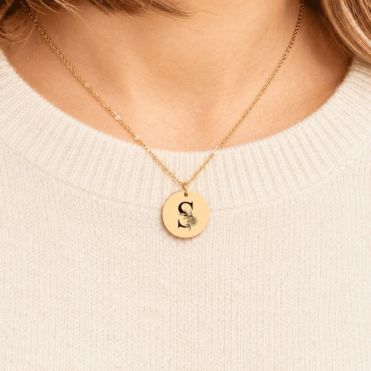 Collier initiale florale S personnalisé doré porté au cou, médaille ronde gravée.
