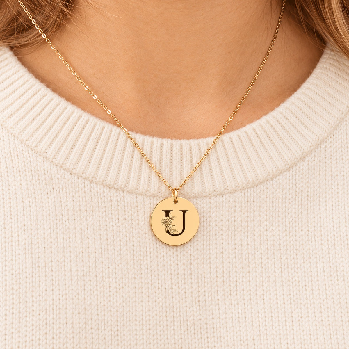 Collier initiale florale U personnalisé doré porté au cou, médaille ronde gravée.