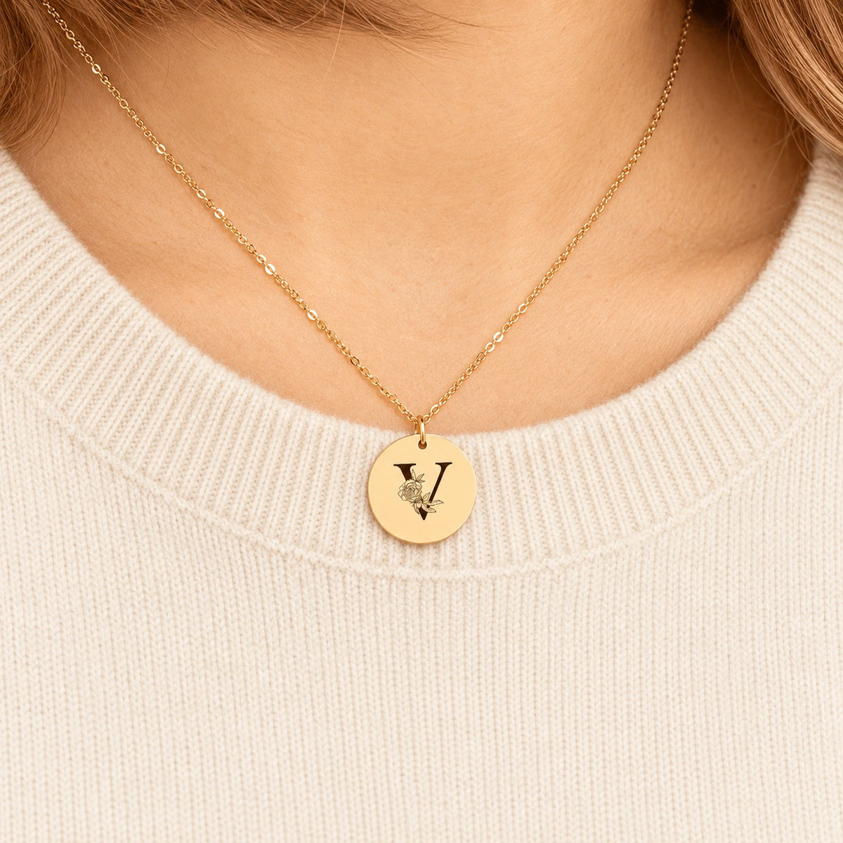Collier initiale florale V personnalisé doré porté au cou, médaille ronde gravée.