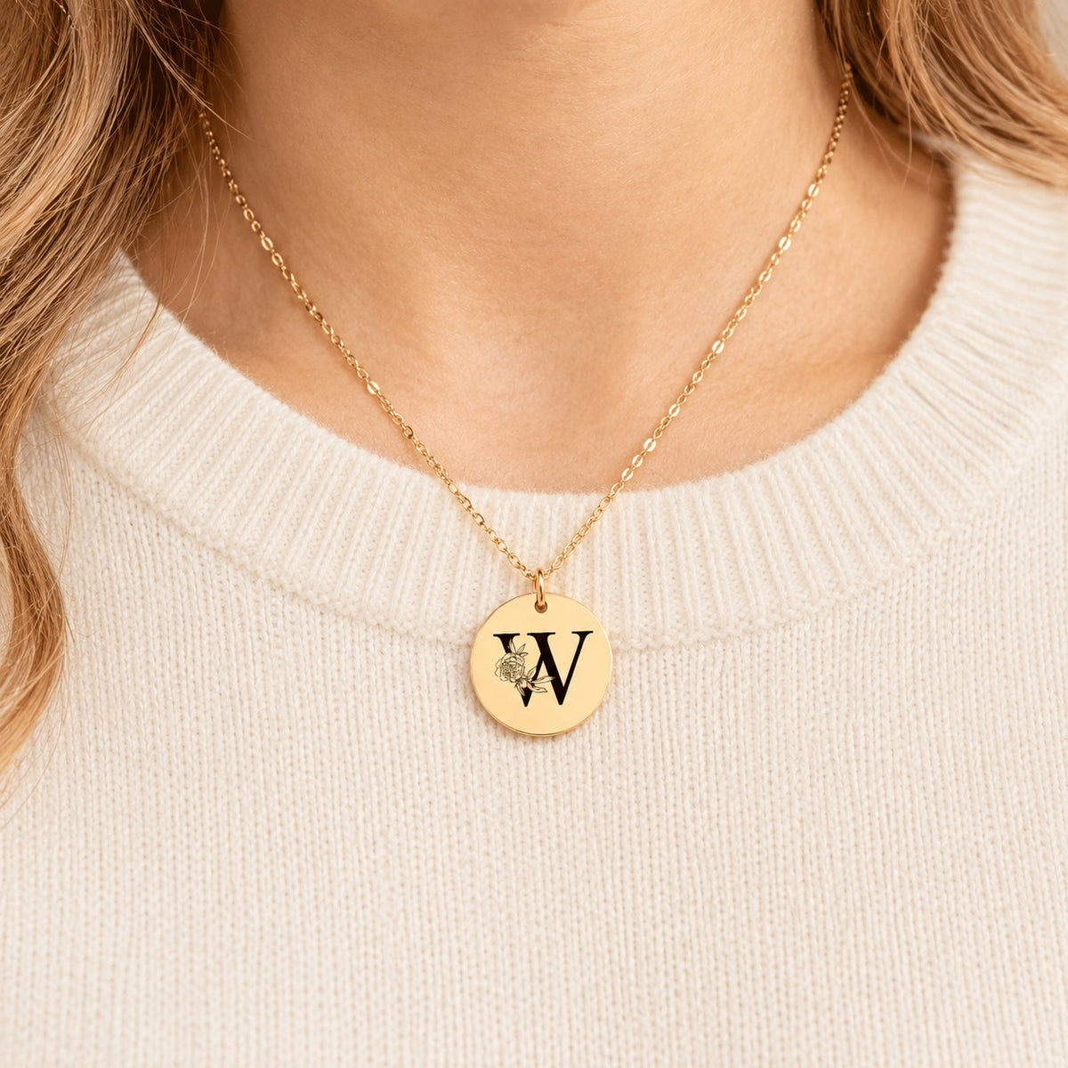 Collier initiale florale W personnalisé doré porté au cou, médaille ronde gravée.