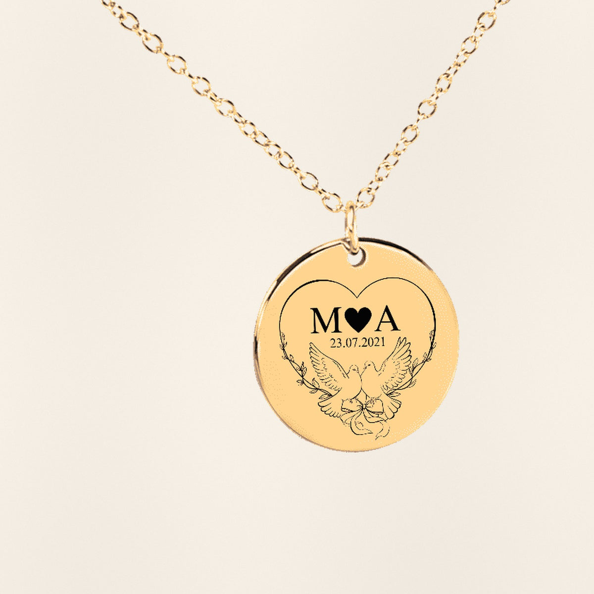 Collier Initiales Entrelacées Personnalisé (Timeless Bond) en finition dorée, exemple de gravure sur fond ivoire texturé.