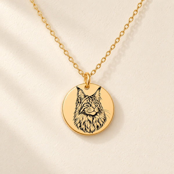 Collier Maine Coon doré avec portrait de Maine Coon gravé, sur fond ivoire.