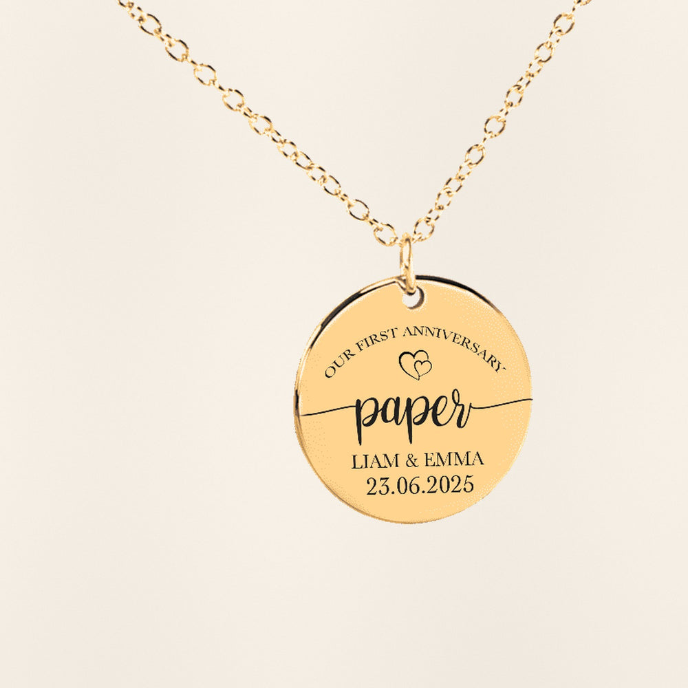 Collier Médaille Anniversaire de Mariage 1 an (noces de coton) en finition dorée, exemple de gravure sur fond ivoire texturé.