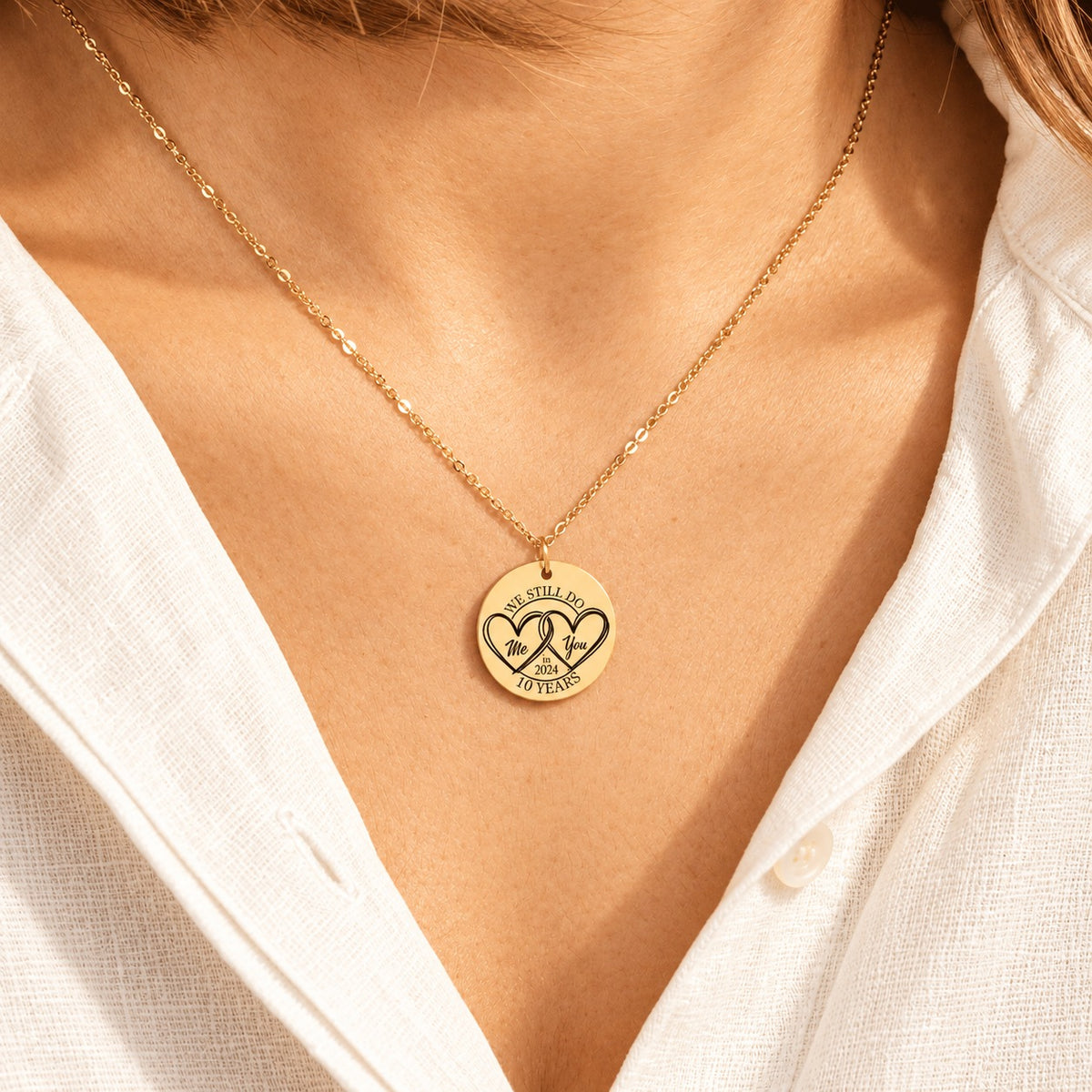 Collier médaille anniversaire de mariage 10 ans doré porté au cou, avec médaille ronde gravé.