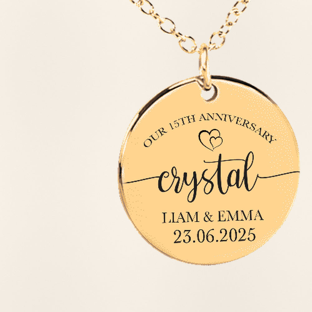 Collier Médaille Anniversaire de Mariage 15 ans (noces de cristal) : gros plan du motif gravé, exemple de personnalisation en finition dorée.