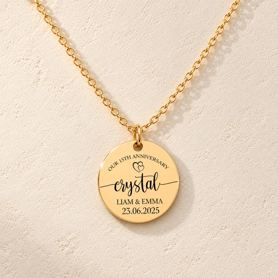 Collier Médaille Anniversaire de Mariage 15 ans doré, médaille ronde gravée avec inscription « crystal », prénoms Liam et Emma et date 23.06.2025, sur fond ivoire.