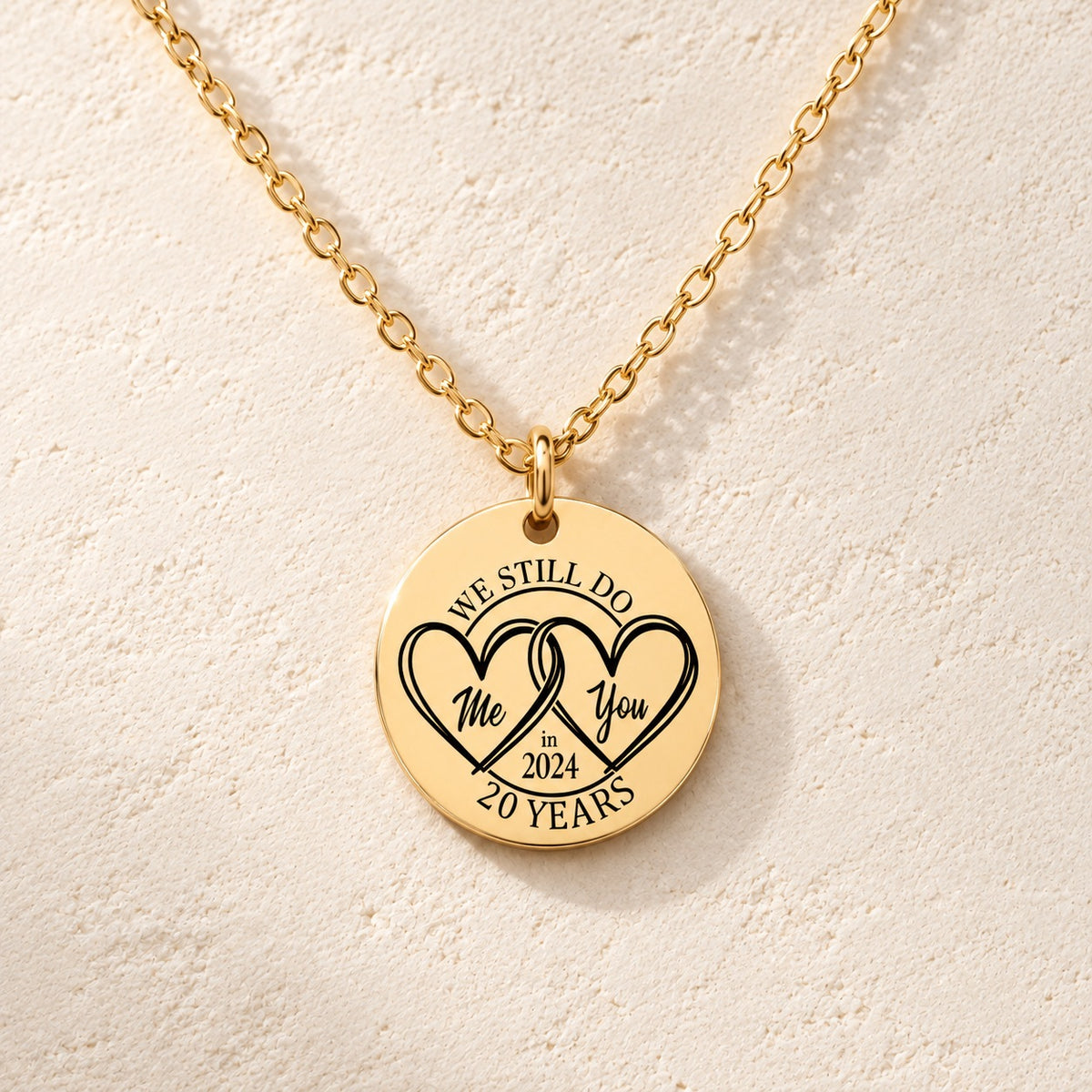 Détail de la médaille ronde dorée avec deux cœurs et inscription « 20 YEARS ».