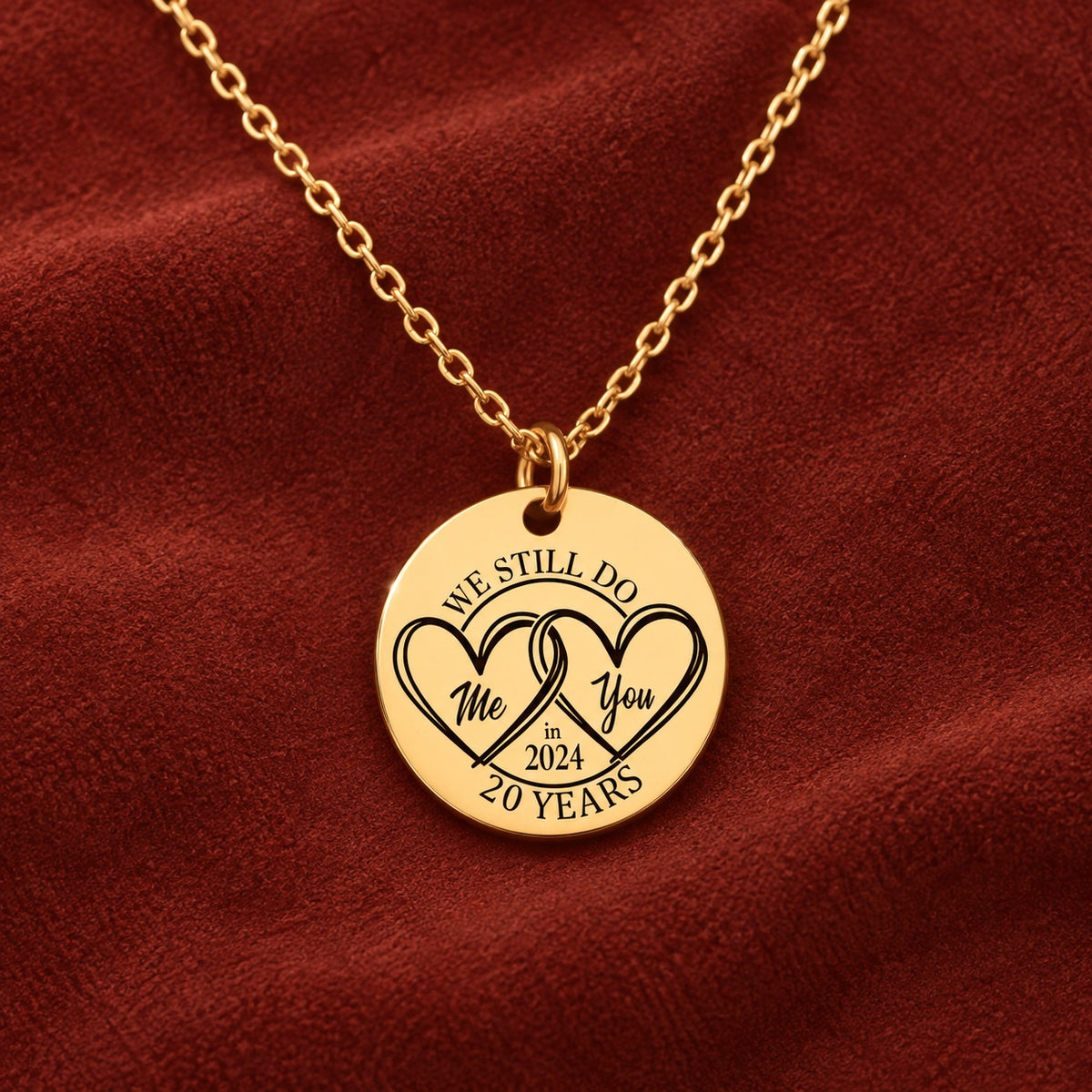 Médaille ronde dorée avec deux cœurs et inscription « 20 YEARS », sur suédine rouge sanguine.