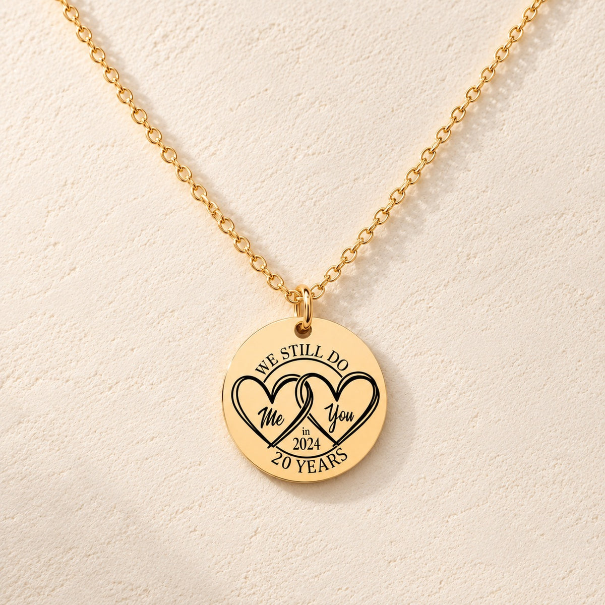 Collier Médaille Anniversaire de Mariage 20 ans doré, médaille ronde gravée avec deux cœurs et inscription « 20 YEARS », sur fond ivoire.