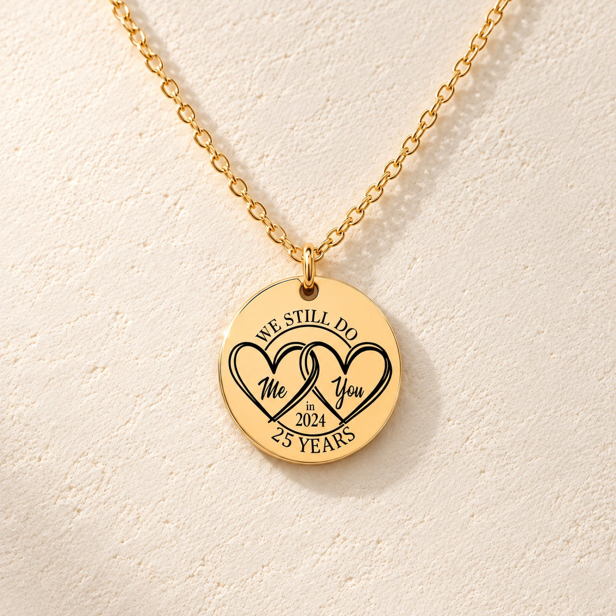 Détail de la médaille ronde dorée avec deux cœurs et inscription « 25 YEARS ».
