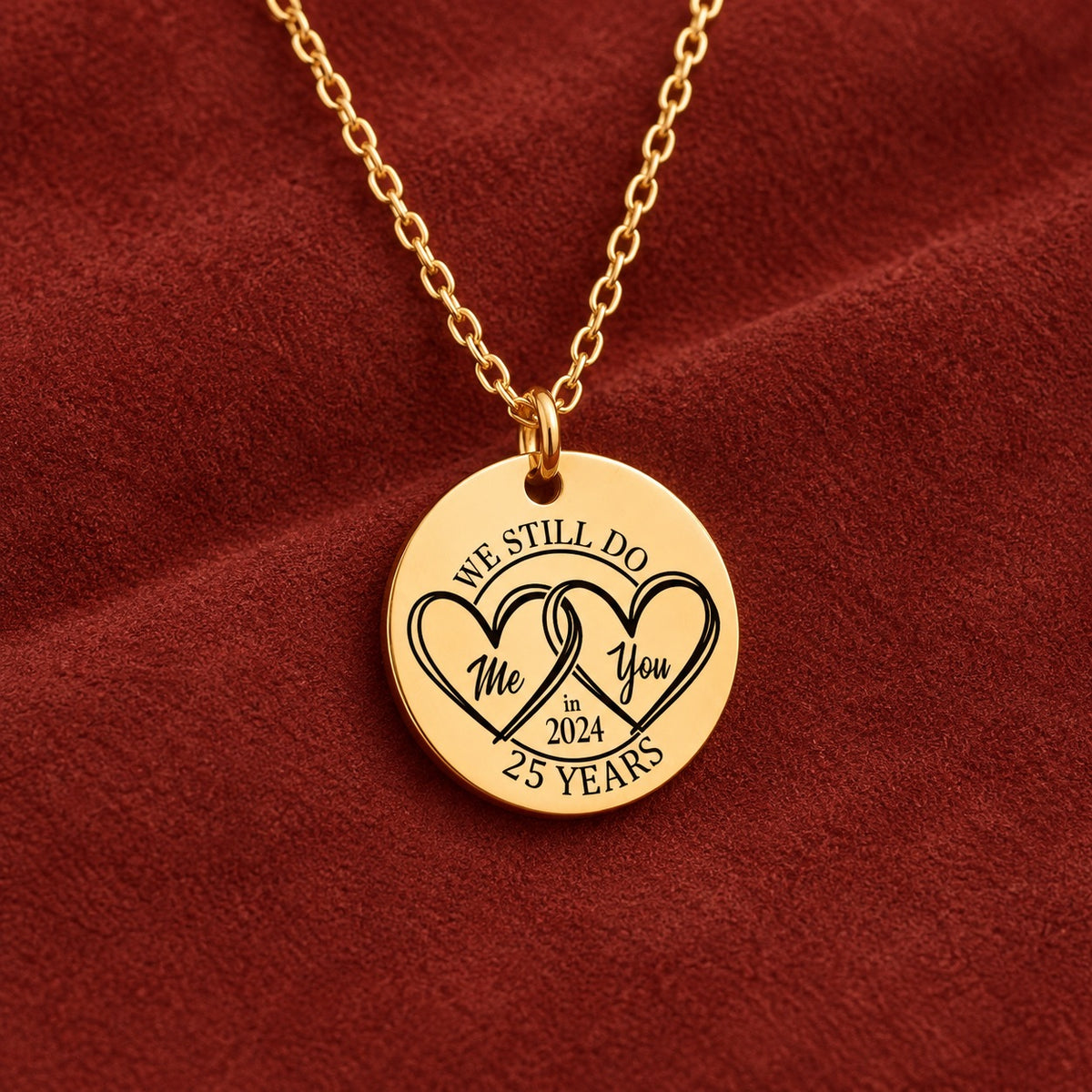 Médaille ronde dorée avec deux cœurs et inscription « 25 YEARS », sur suédine rouge sanguine.