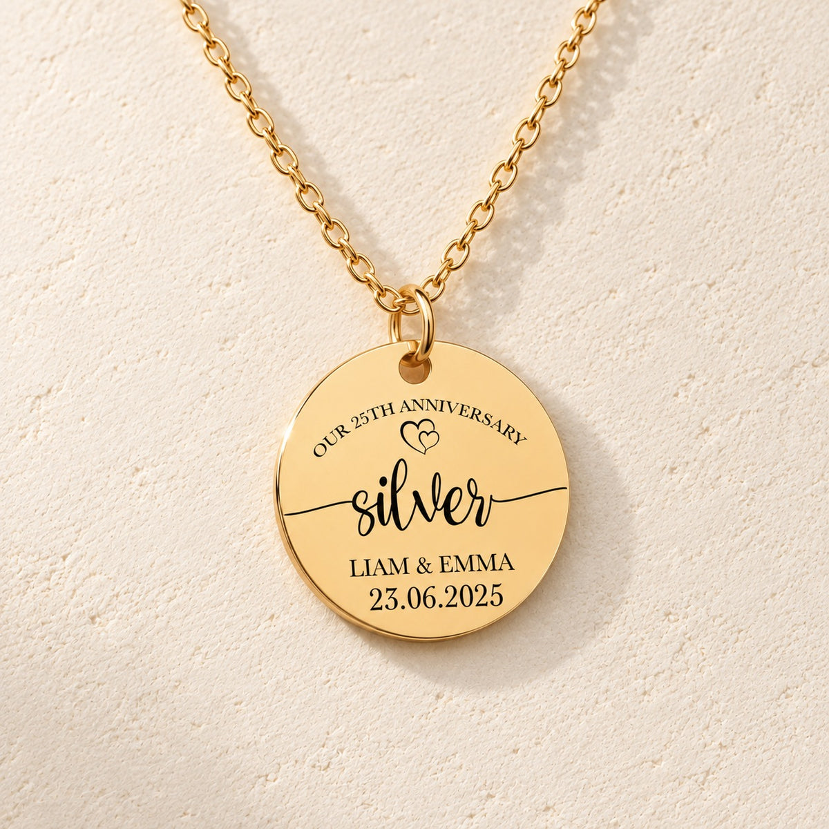 Détail de la médaille ronde dorée avec inscription « silver », prénoms Liam et Emma et date 23.06.2025.