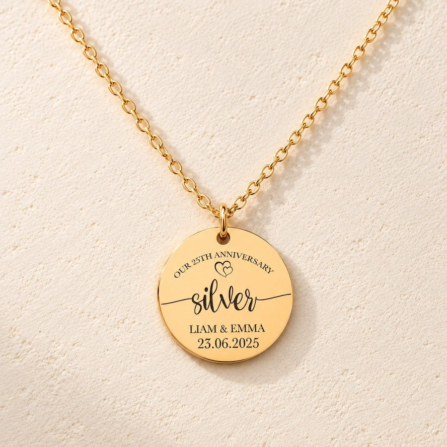 Collier médaille noces d’argent 25 ans doré, médaille ronde gravée avec inscription « silver », prénoms Liam et Emma et date 23.06.2025, sur fond ivoire.