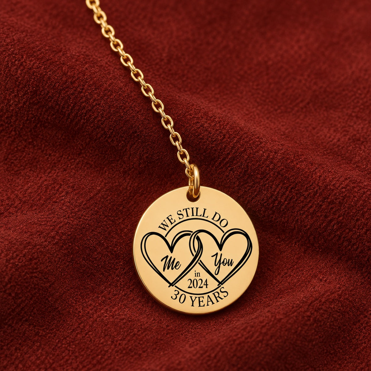 Médaille ronde dorée avec deux cœurs et inscription « 30 YEARS », sur suédine rouge sanguine.
