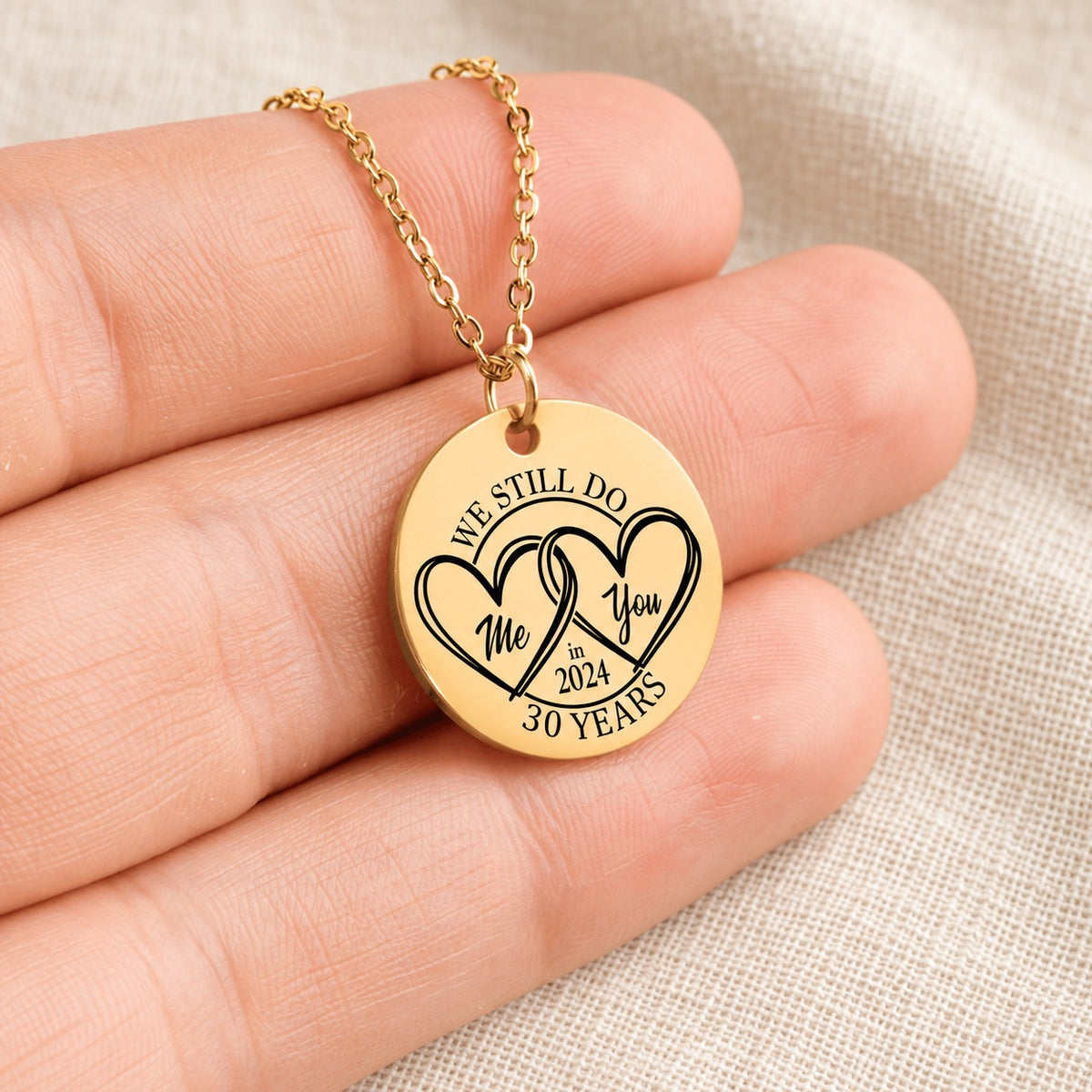 Collier Médaille Anniversaire de Mariage 30 ans doré tenu en main, détail de la gravure.