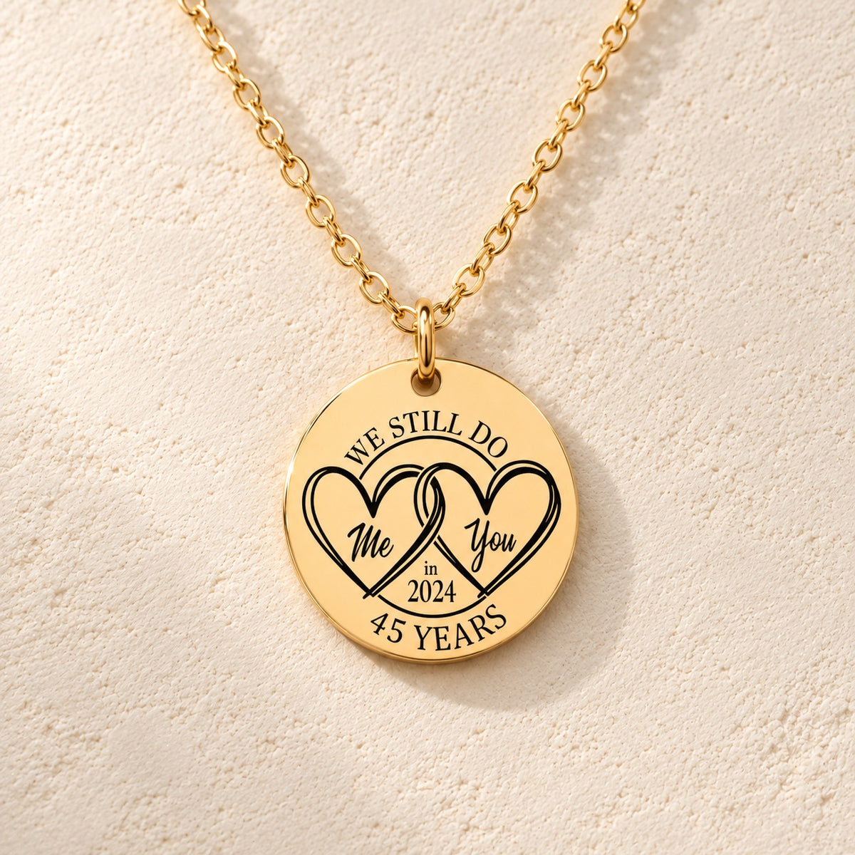 Détail de la médaille ronde dorée avec deux cœurs et inscription « 45 YEARS ».