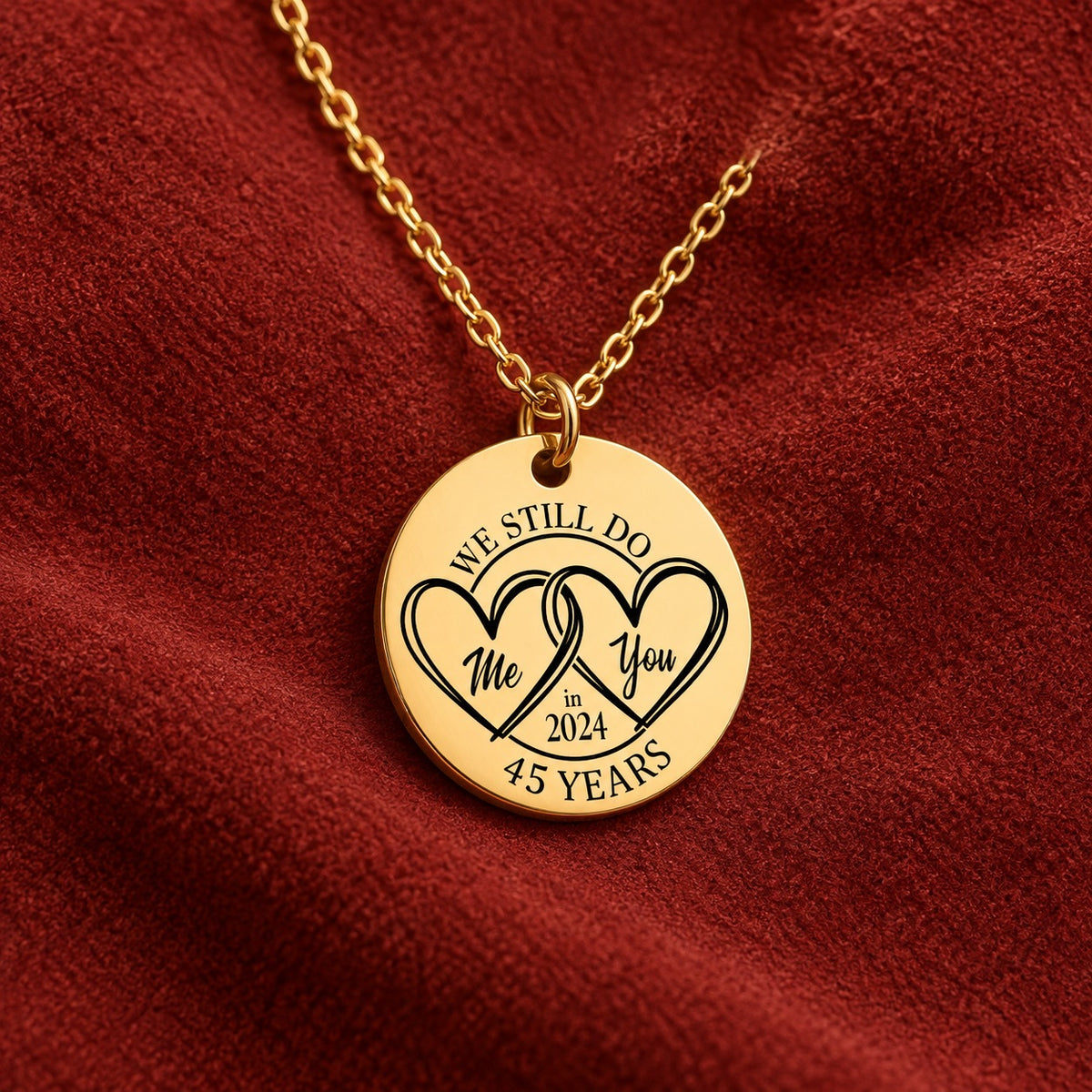 Médaille ronde dorée avec deux cœurs et inscription « 45 YEARS », sur suédine rouge sanguine.