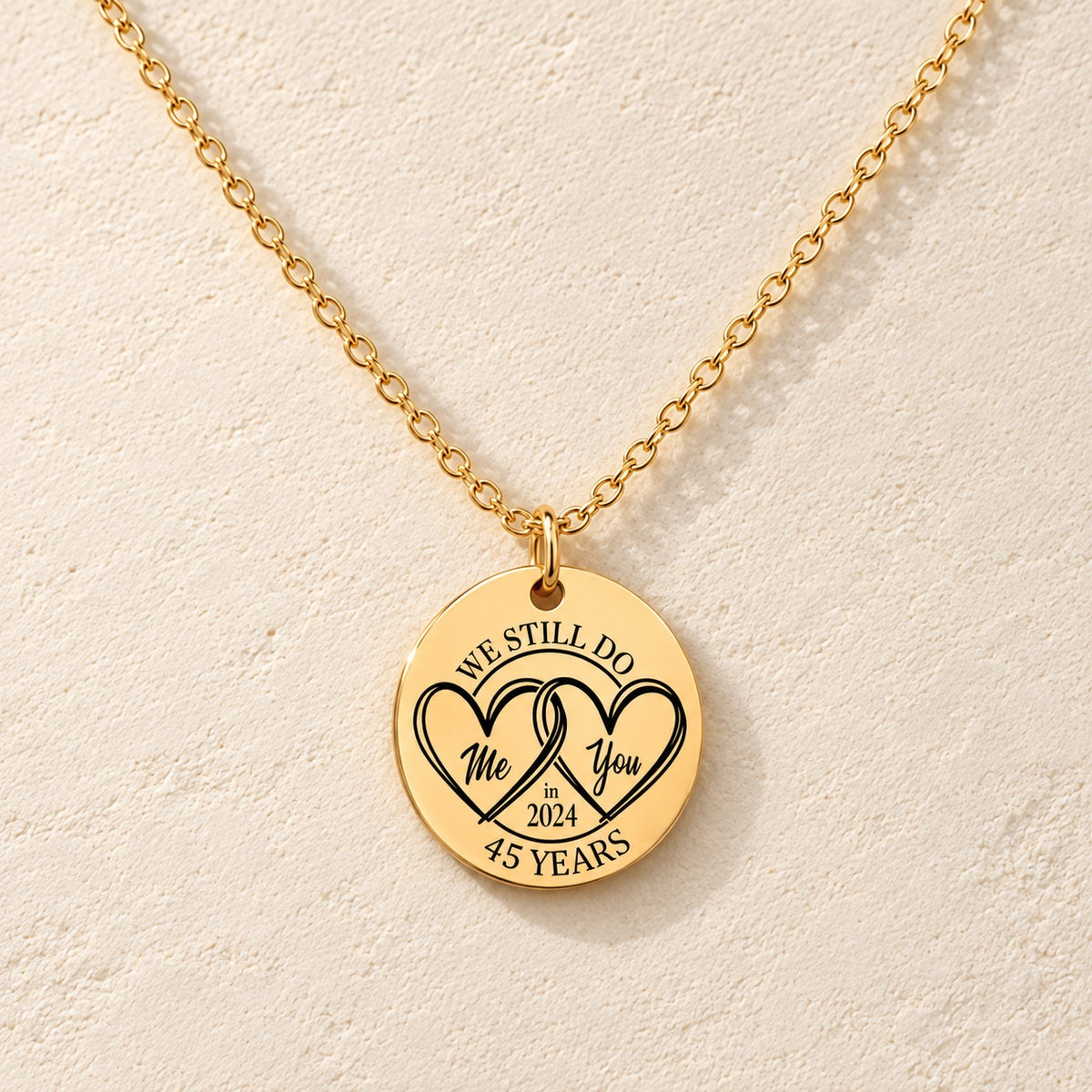 Collier Médaille Anniversaire de Mariage 45 ans doré, médaille ronde gravée avec deux cœurs et inscription « 45 YEARS », sur fond ivoire.