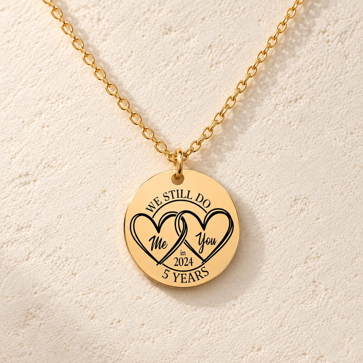 Détail de la médaille ronde dorée avec deux cœurs et inscription « 5 YEARS ».